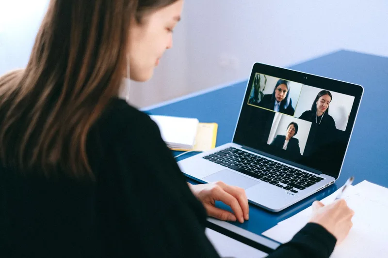 A person on a video call with notes in hand, conducting a customer discovery conversation before building a course