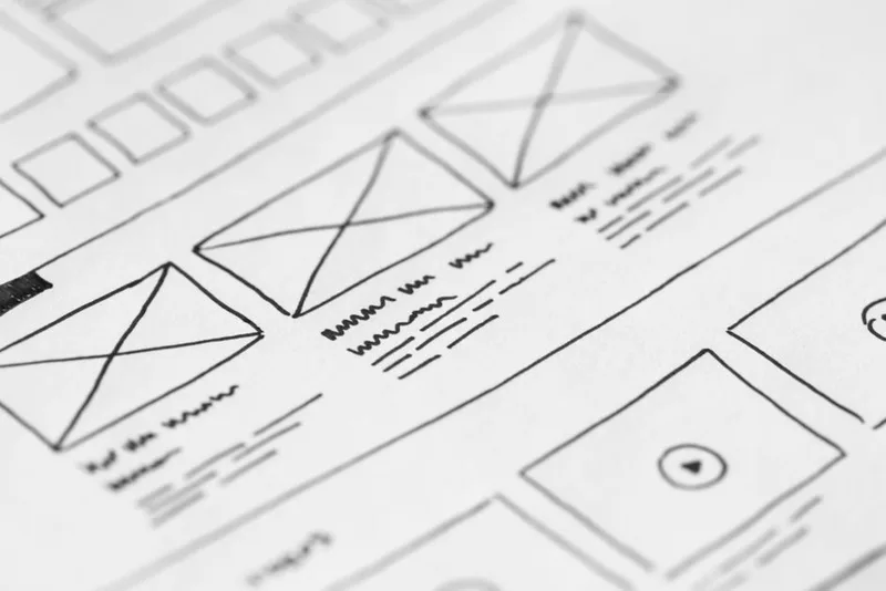 Close-up of a hand-drawn wireframe sketch on paper, laying out a page design before any code is written