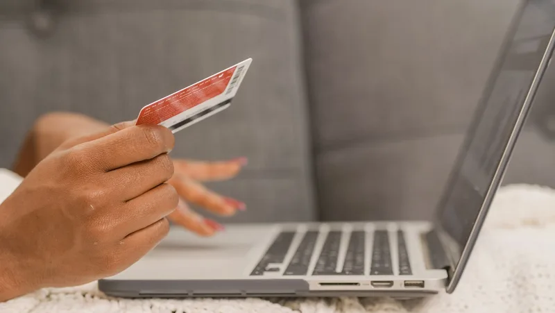 A person entering payment details on a laptop, representing a pre-sell test used to check whether strangers will commit money to validate a business idea