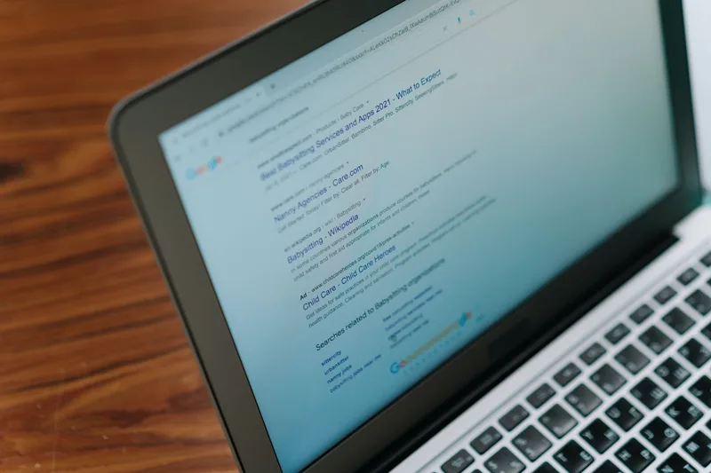 A laptop showing a simple landing page — a single headline, one paragraph, and one call to action button