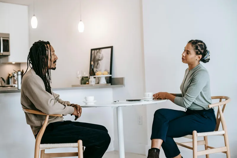 Two people in conversation — one listening carefully while the other explains a problem